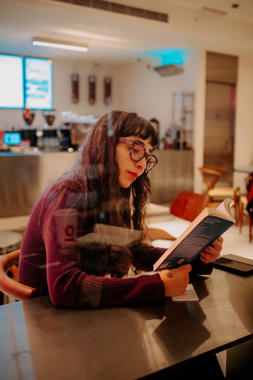 young woman reading book in cozy cafe setting